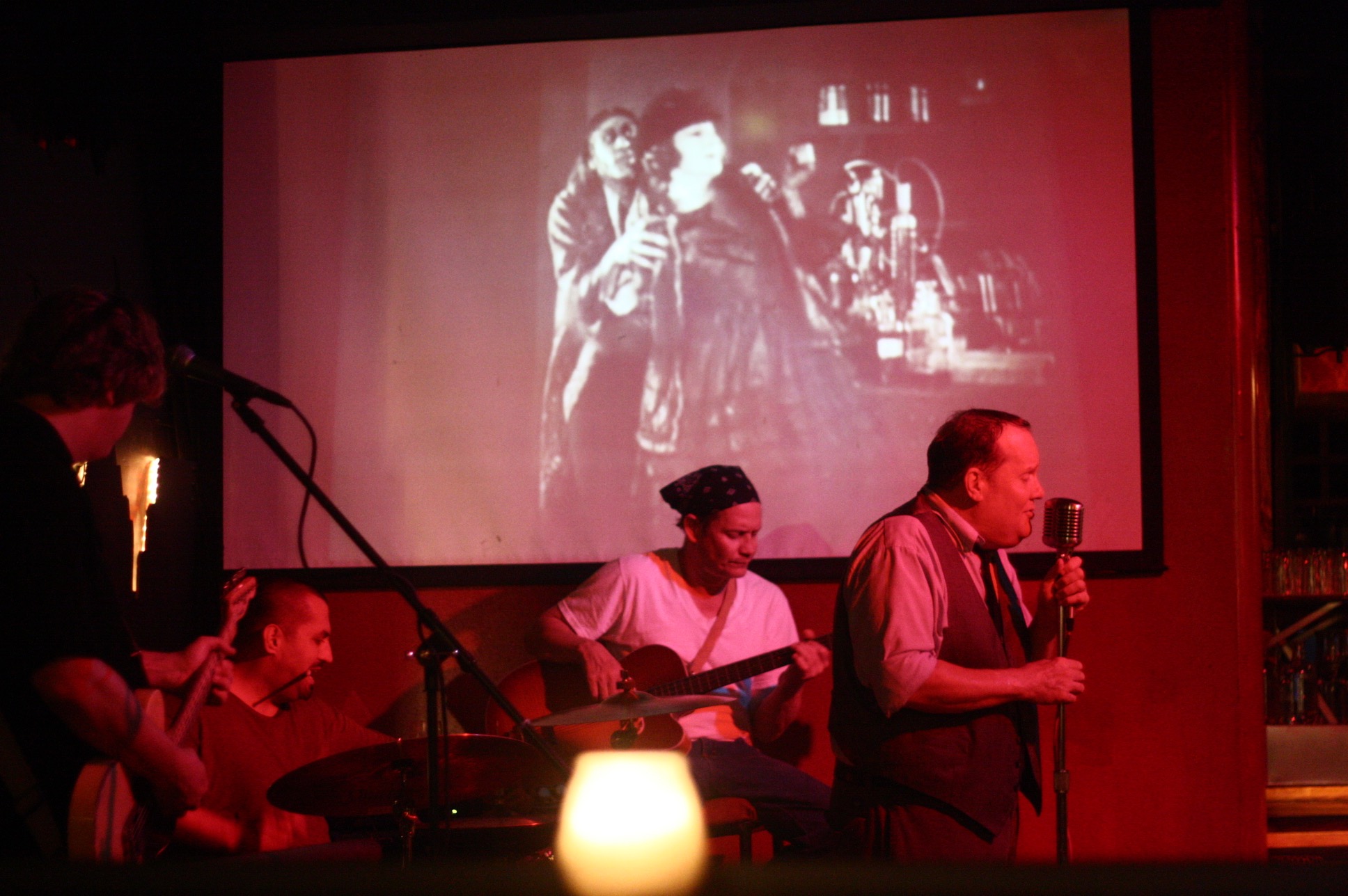 Jazz band performing with vintage microphone and projected film at Firehouse Lounge
